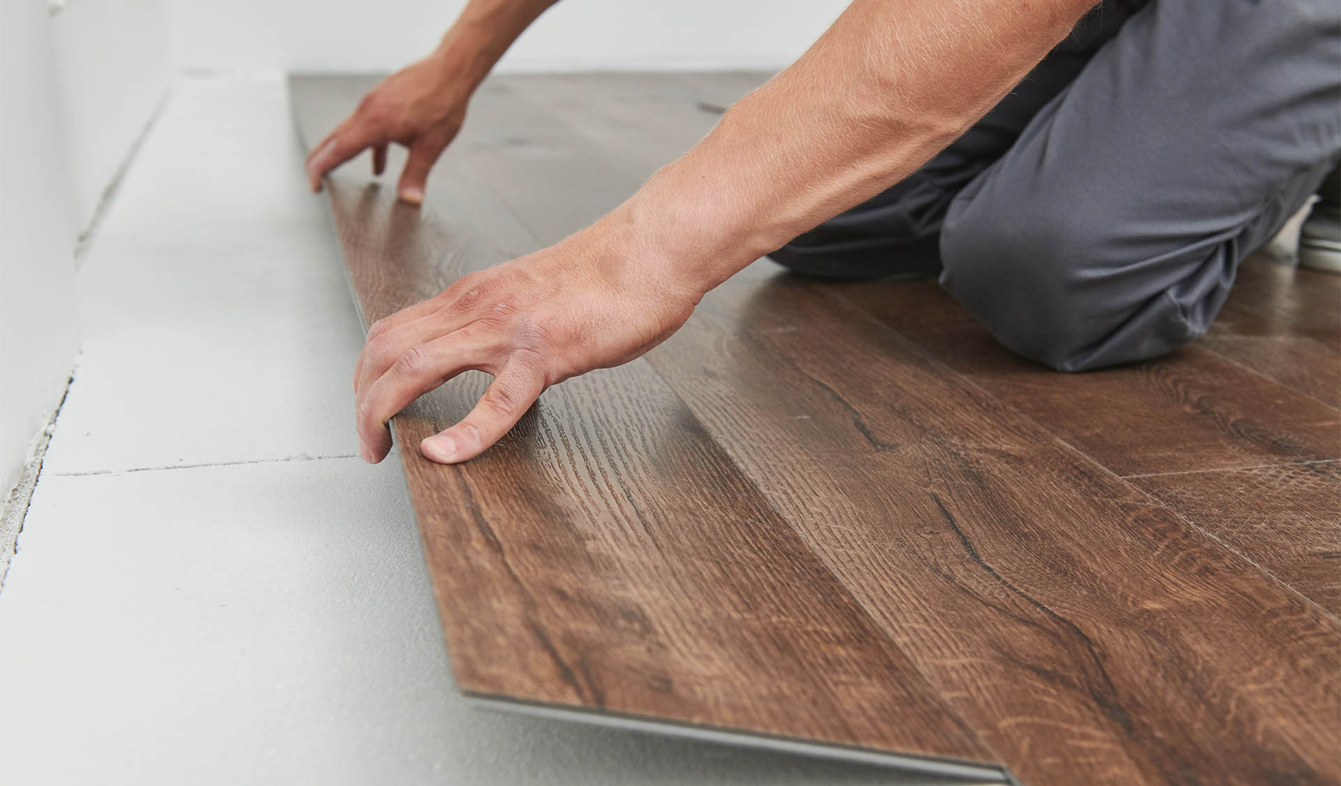 worker joining vinyl floor covering new construction home