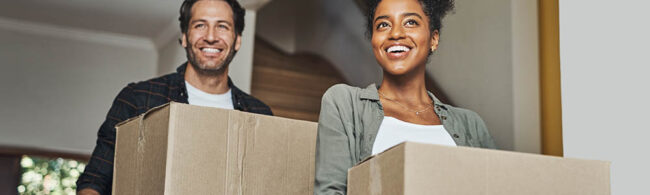 New house, moving and happy couple carrying boxes while feeling proud and excited about buying a house with a mortgage loan. Interracial husband and wife first time buyers unpacking in dream home