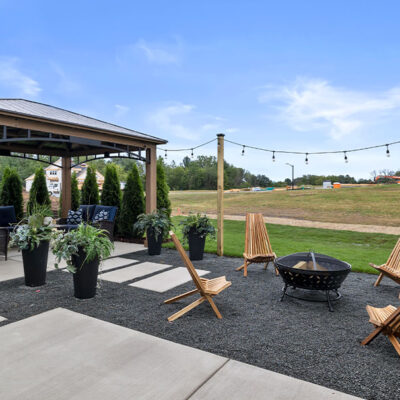 Parade of Homes model, The Lexi, backyard entertaining space featuring a fire place and sitting furniture under a gazebo