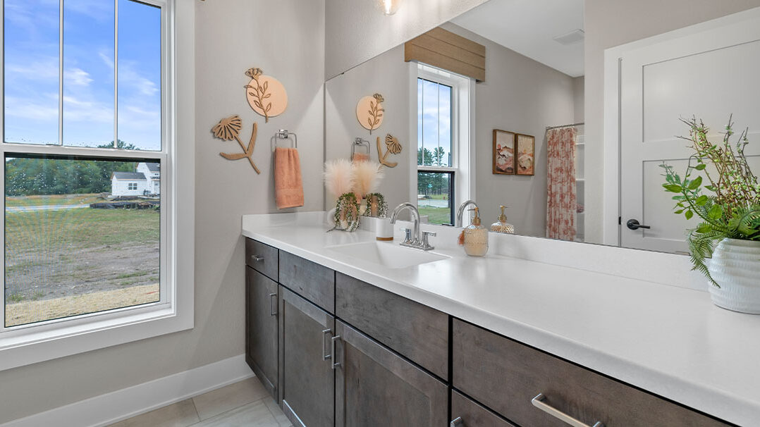 Parade of Homes model, The Lexi, secondary full bathroom features bright white counters with contrasting dark wood lowers.